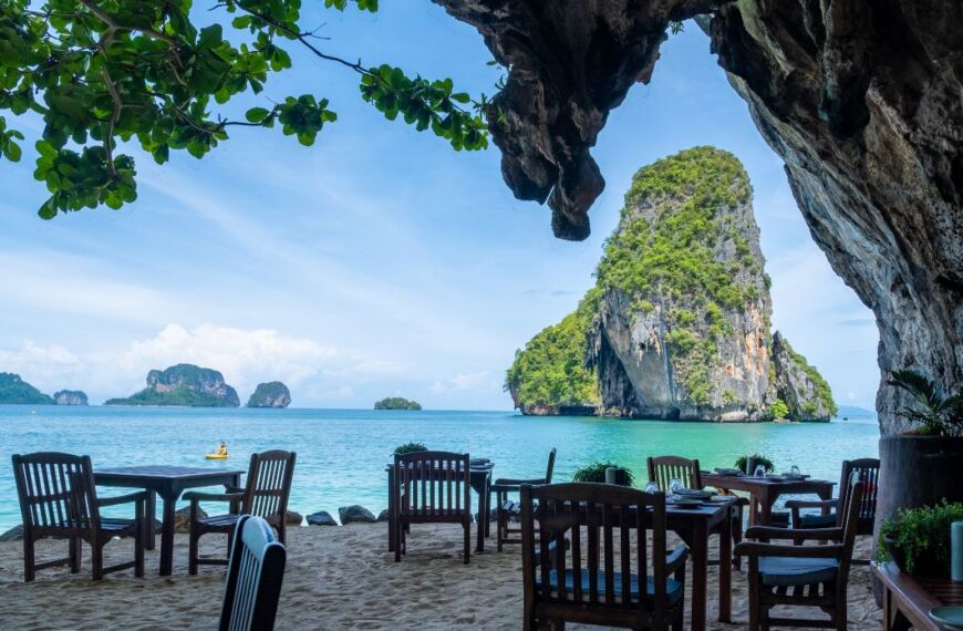 wooden chairs on sand in cave at Railay Beach
