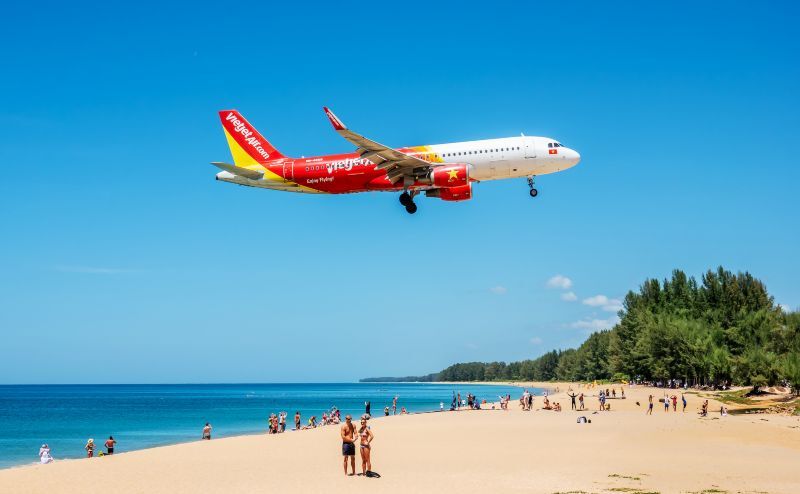 Photo of a plane coming in for landing,  at Phuket airport, flying above a beach in Phuket, Thailand