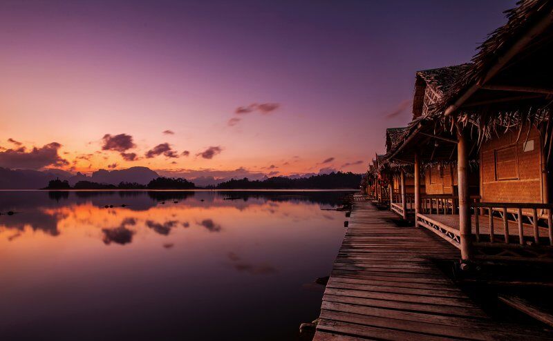 Floating Bungalows at Khao Sok National Park with Cheow Lan lake and mountains at sunrise, Thailand.