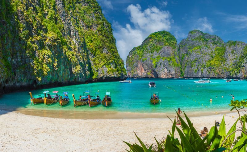 Photo of the idyllic Maya Bay on Phi Phi Lay showing many boats in the water, Phi Phi Lay, Thailand