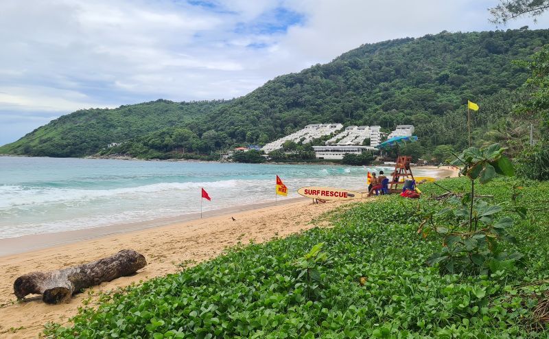 Photo of Nai Han Beach Southern Phuket, with the green headland and tropical foliage coming to the end of the sand, Phuket, Thailand