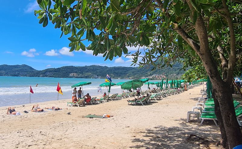 Photo of a Phuket beach with green sun loungers and deck chairs, Phuket, Thailand
