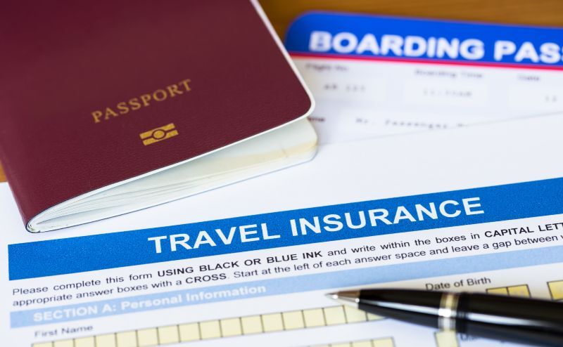 Travel insurance application form with pen and passport