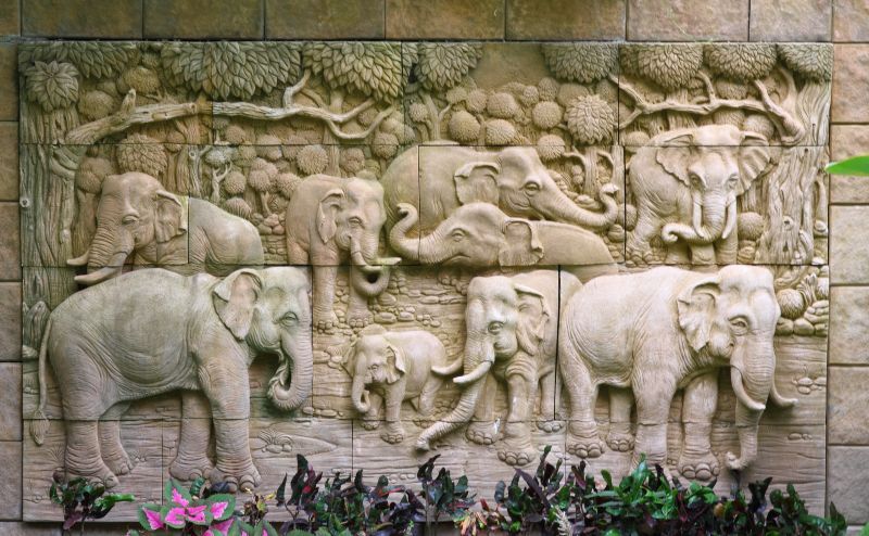 Woodcarvings of elephants on a wall in Thailand
