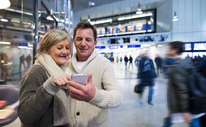 Couple using a phone in an airport