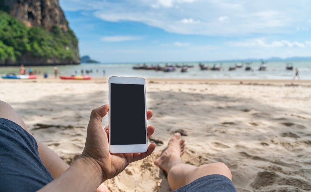 Using a smartphone on the beach in Thailand