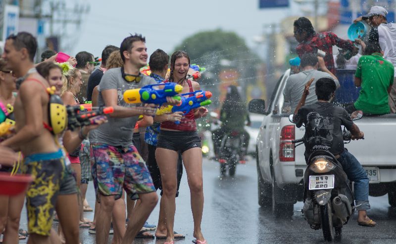 Foreigners and Thai people enjoy splashing water together in songkran festival 