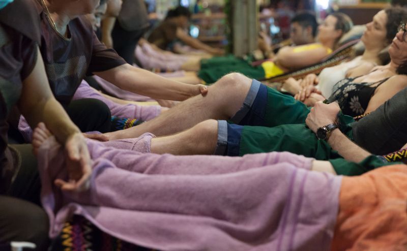 View of many tourists having a short break with a thailand foot massage after a long day in Bangkok city streets.