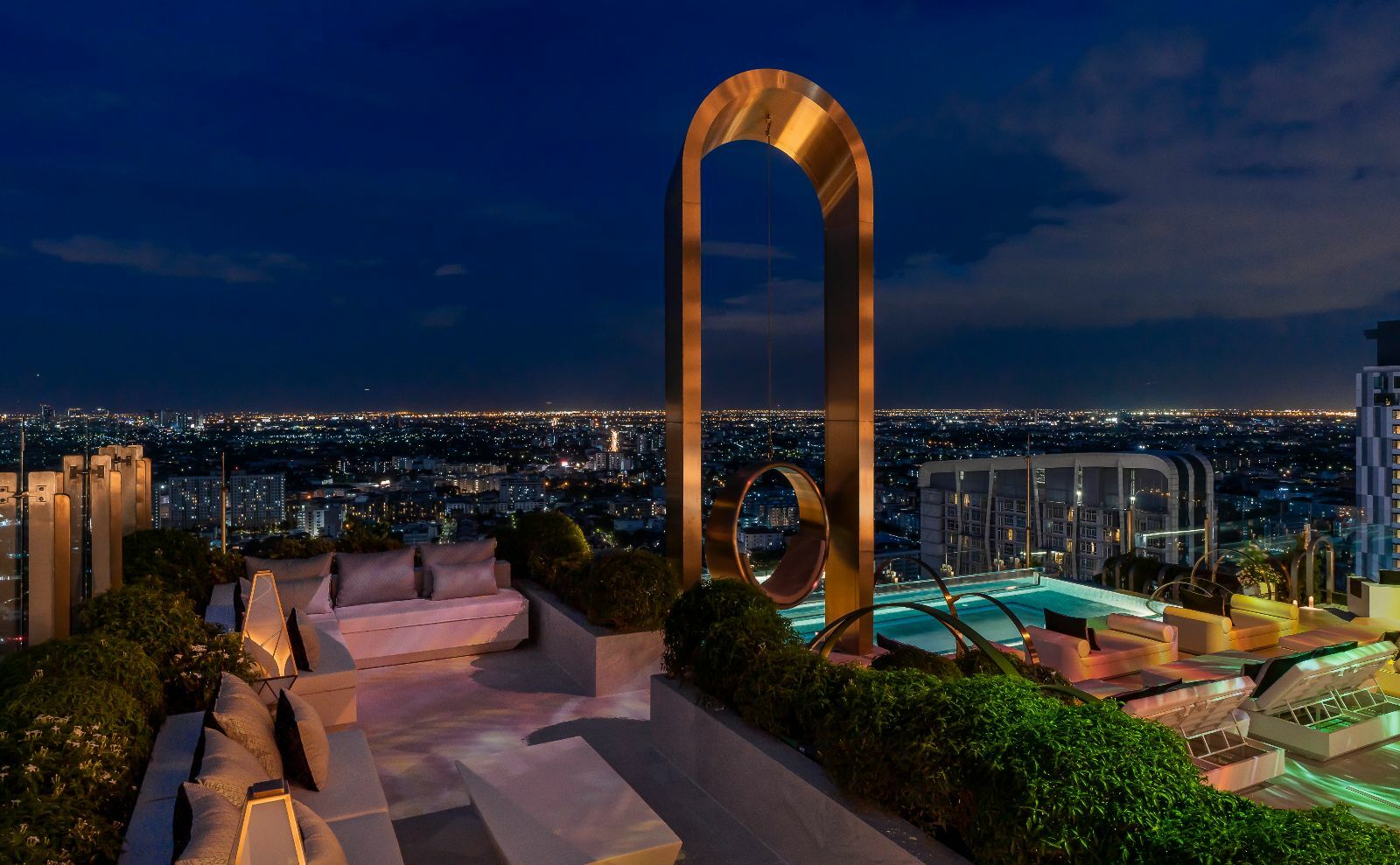 a rooftop with a pool and a large arch