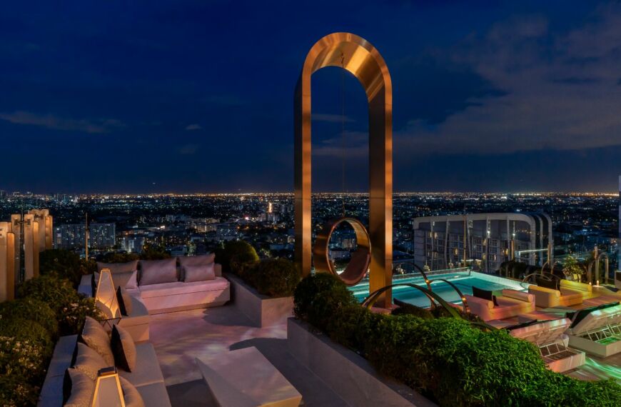 a rooftop with a pool and a large arch