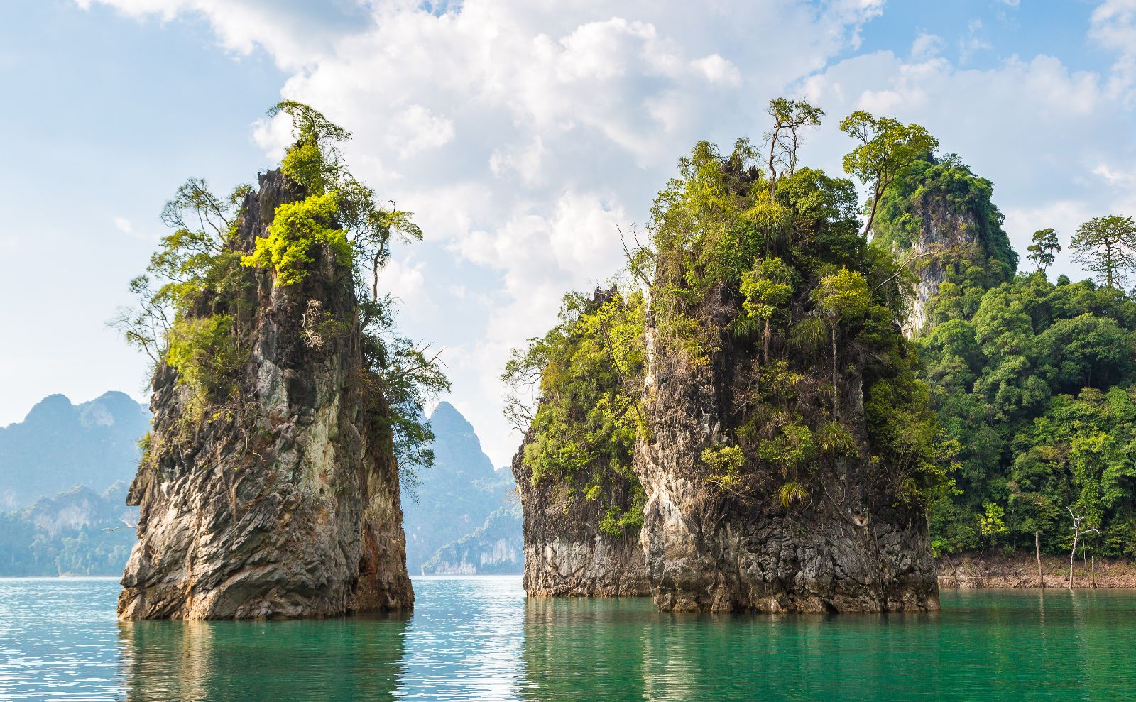 Limenstone rocks at Cheow Lan lake, Ratchaprapha Dam, Khao Sok National Park in Thailand in a summer day
