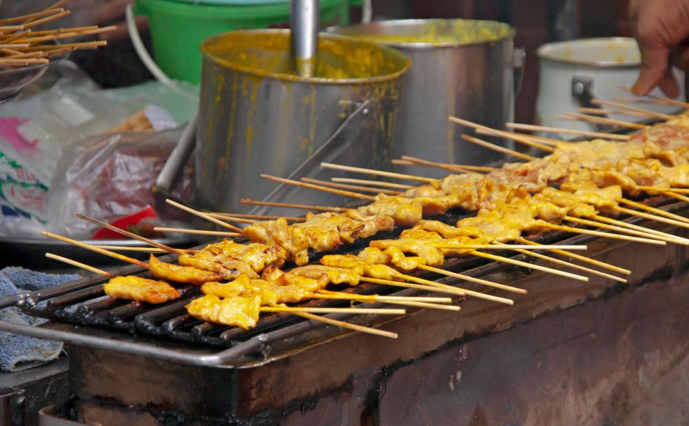 Satay Skewers cooking on a grill 